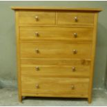 A reproduction oak chest of drawers the rectangular top above two short and four long graduated