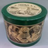 A reproduction hat box labelled for The Indestructible Trunk and Container Company in green and