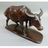 A hardwood carving water buffalo on stand, 20cm high x 30.5cm long