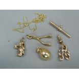 A small collection of 9ct gold jewellery including charms, a swivel fastener, T.bar, two charms