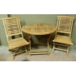 A pair of teak garden reclining chairs together with a circular folding table