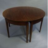 A George III mahogany extending dining table with pair of D- Shaped ends, deep friezes with