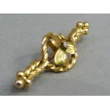 An Edward VII diamond set shamrock bar brooch in 15ct gold claw set to the leaf centre with a