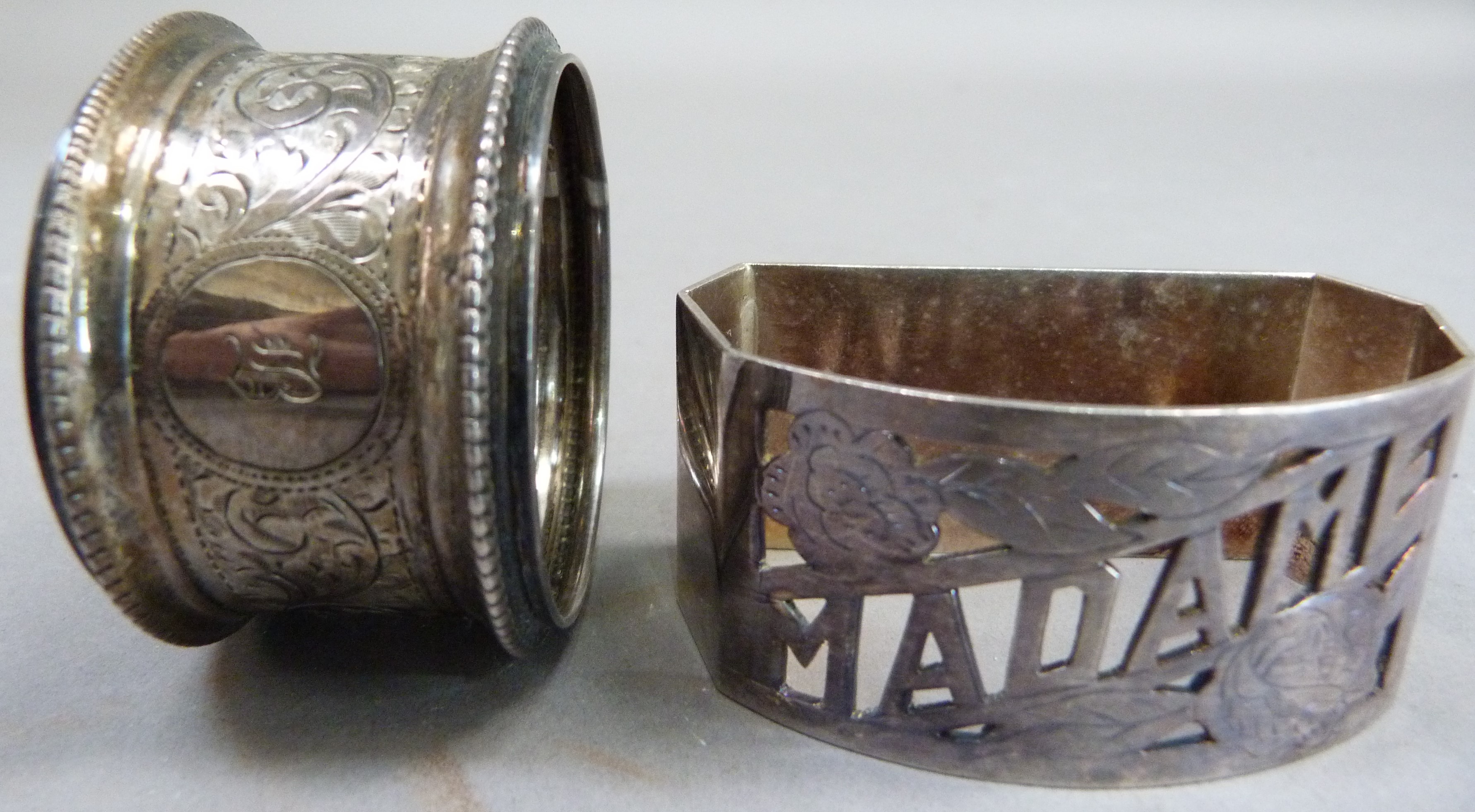 A silver napkin ring engraved with foliate leaf curls, with initial together with a white metal - Image 3 of 4