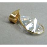 A pendant set with a pear shaped cubic zirconia in a yellow metal collet (tests as 18ct gold) with