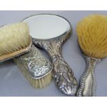 Four silver backed dressing table items of similar cherub design including hand mirror, hairbrush