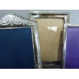 A silver photograph frame of arched rectangular outline embossed with ribboned laurel swags, c.1994,