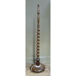 An oak standard lamp with barley twist column on a dished circular base and three feet, 145cm high