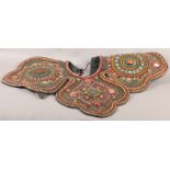 AN ANTIQUE TIBETAN CEREMONIAL SHOULDER CLOAK of four quatrefoil panels centred with polished