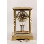 A LATE 19TH CENTURY CONTINENTAL BRASS CASED FOUR GLASS MANTEL CLOCK set with turned and geometric