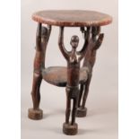 A CARVED HARDWOOD STOOL, the circular top with geometric carved edge supported on three semi-