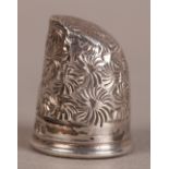 OF SEWING INTEREST - AN EDWARD VII SILVER THIMBLE in the form of a finger tip with all over floral