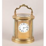 A FRENCH GILT BRASS CARRIAGE CLOCK, oval outline, having a gilt metal face with circular porcelain