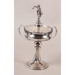 A GEORGE V SILVER PLANISHED CUP AND DOMED COVER, the finial cast as a classical female holding