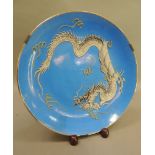 A Nagasaki porcelain plate, heavily enamelled in greys with a dragon on a bright blue ground, 31cm