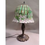 A reproduction resin Tiffany style lamp moulded with leafage and lily pads, the lead glazed shade in