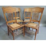 A set of four American style oak dining chairs the concave backs impressed with scrolling leafage on