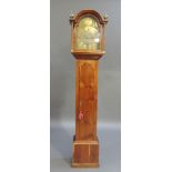 A yew veneered long case clock the arched hood with pair of ball and spire finials enclosing a brass