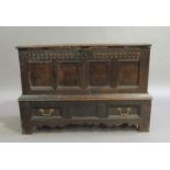 An oak blanket chest on stand the four panelled hinged top above a fluted frieze, four panel front