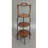 An Edwardian mahogany graduated three tier cake stand outlined throughout with boxwood and harlequin