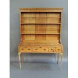 A reproduction pine dresser in George II style, the cornice above a bordered shelved back the