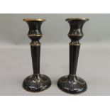 A pair of black cloisonne enamel table candlesticks with scaled ground, the circular bases set