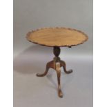 A reproduction mahogany George III style occasional table, the pie crust top above an acanthus