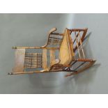 An American style rocking chair, the concave back impressed with scrolling leafage above spindle