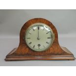 A walnut veneered arched mantle clock circa 1930's the figured front with hinged brass bezel