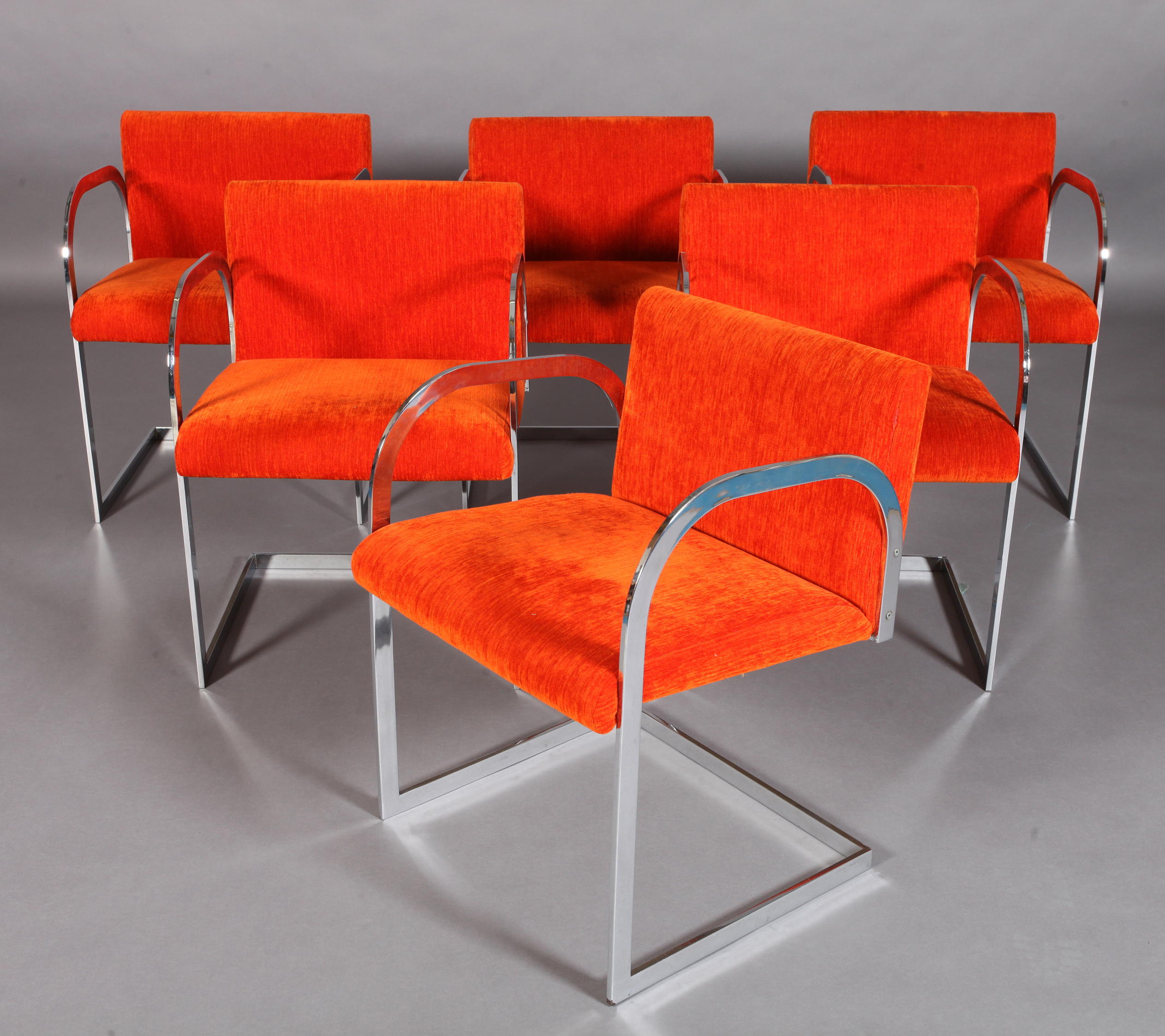 A SET OF SIX ITALIAN CHROMIUM PLATED STEEL CANTILEVER DINING CHAIRS, c.1970, with arch-profile arms,