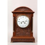 An Edward VII mahogany cased mantel clock ,the arched top shell carved above a flared cornice, the