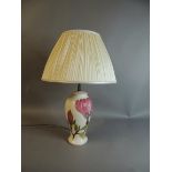 A Moorcroft table lamp, tube lined and enamelled in mauve, green and brown on a cream