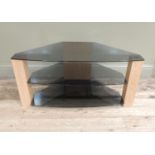 A modern three tier smoked glass television stand on faux oak supports, 95cm wide