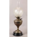 A late 19th Century brass oil lamp, the reservoir embossed with palmettes and scrolls, opaque etched