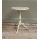 A modern cream painted wine table, circular top on baluster turned column and three swept legs,