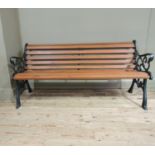 A reproduction Victorian style cast metal bench with slatted back and seat