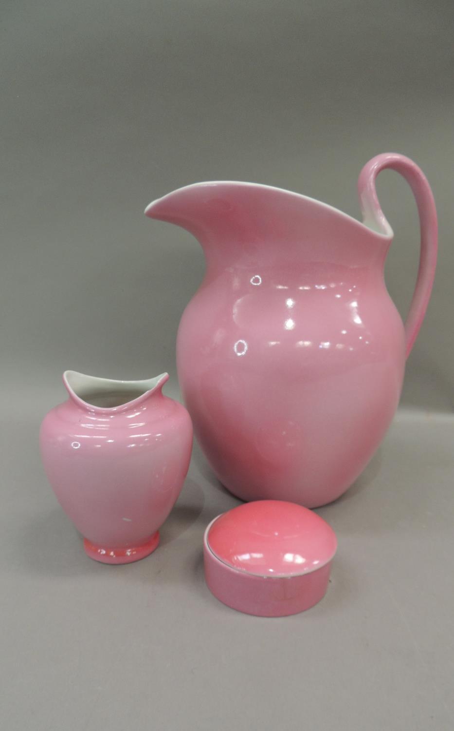 An early 20th century pink glazed toilet jug, vase, soap dish and cover