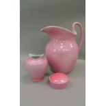 An early 20th century pink glazed toilet jug, vase, soap dish and cover