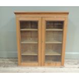 A pine bookcase top enclosed by a pair of glazed doors, 92cm x 104cm high