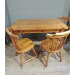 A reproduction pine dining table, the thick top on turned legs; together with three spindle back