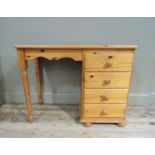 A reproduction pine single pedestal desk with rectangular top, the right side fitted four short