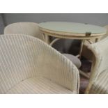 A cream painted circular two tier wicker table with glass top together with a set of four cream