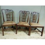 A set of three mahogany dining chairs with pierced 'gothic' splats, drop in seats in brown leather