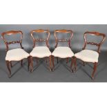A set of four Victorian Rosewood Dining Chairs with shaped backs and foliate scroll carved
