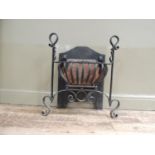 A fire basket with arched back, the raised basket railed with wrought iron scrolling posts and