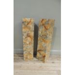 A pair of speakers in faux marble square cabinets, 106cm high