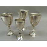 Four silver goblets, three bearing presentation inscriptions the smallest with vacant cartouche,