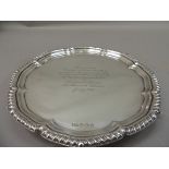 A George III style silver salver with gadrooned rim, the centre bearing presentation inscription,