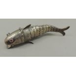 A continental silver articulated fish pill box with red glass eyes and hinged mouth, 11.5cm long,