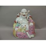 A ceramic figure of Hotei, the buddha with small children climbing over him, 25cm high